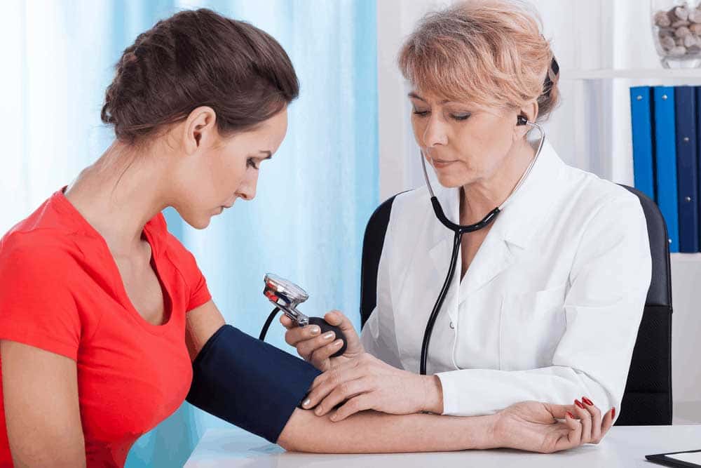 Image of Doctor Taking Blood Pressure Female Patient